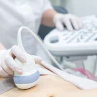 Young woman undergoing ultrasound scan in modern clinic